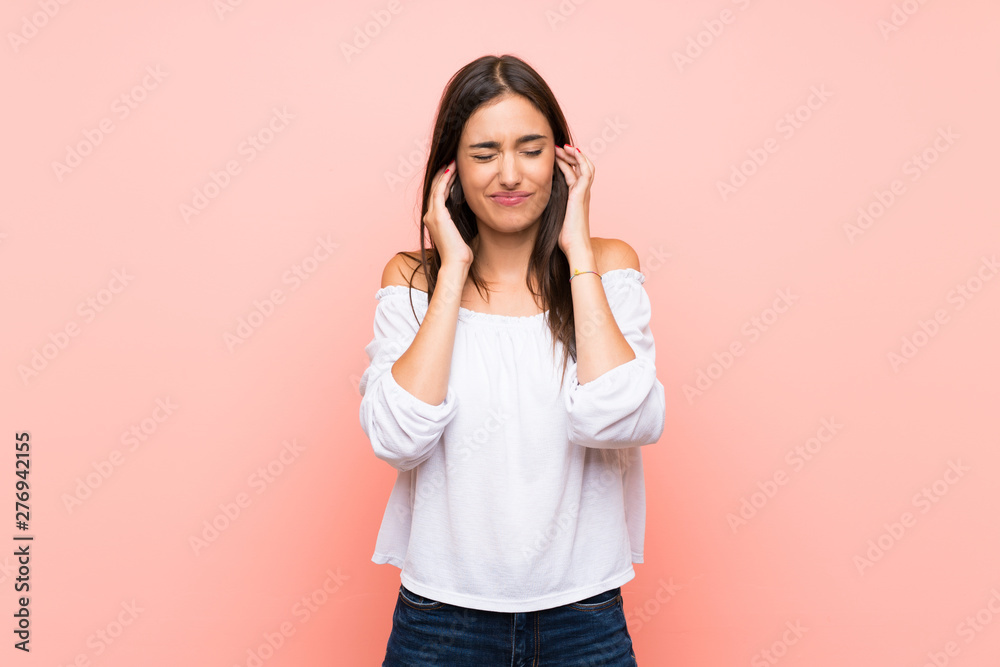 Young woman over isolated pink background frustrated and covering ears Young woman over isolated pink background frustrated and covering ears