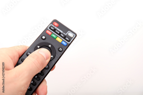 Hand pressing remote control isolated on white background.