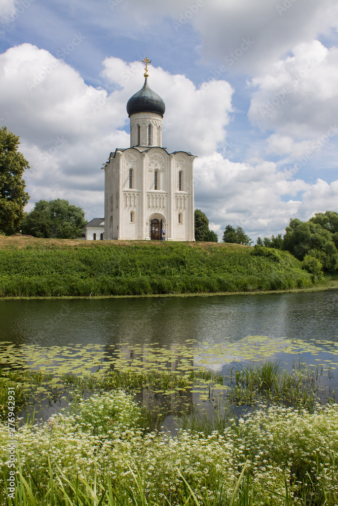 White stone Church of the Intercession on the Nerl with reflection in the water summer day Russia White stone Church of the Intercession on the Nerl with reflection in the water summer day Russia