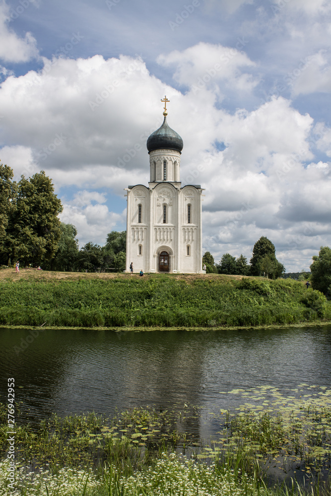 White stone Church of the Intercession on the Nerl with reflection in the water summer day Russia White stone Church of the Intercession on the Nerl with reflection in the water summer day Russia