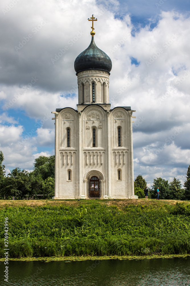 White stone Church of the Intercession on the Nerl with reflection in the water summer day Russia