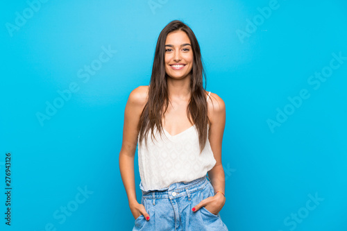 Young woman over isolated blue background laughing photo
