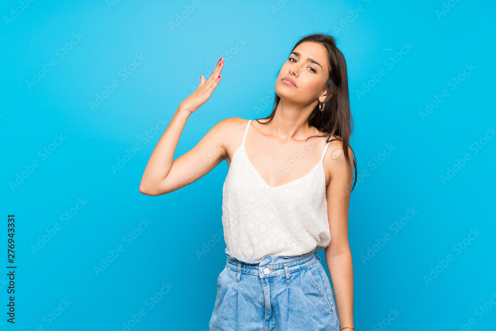Fototapeta premium Young woman over isolated blue background with tired and sick expression