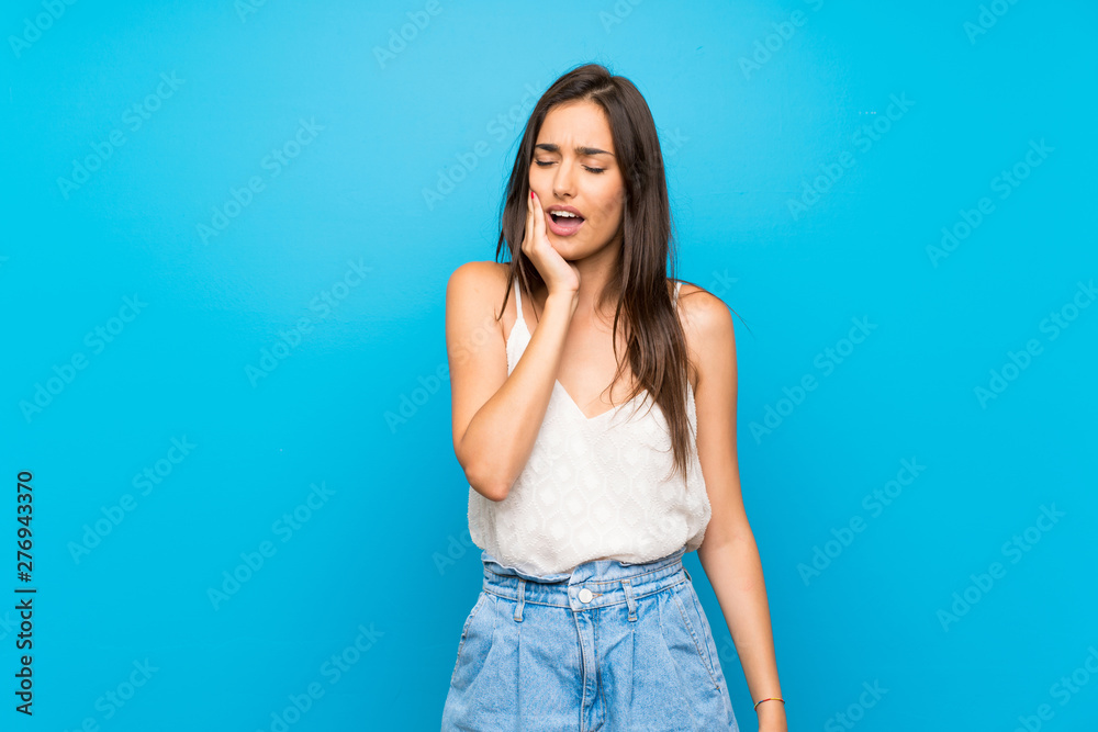 Young woman over isolated blue background with toothache Young woman over isolated blue background with toothache