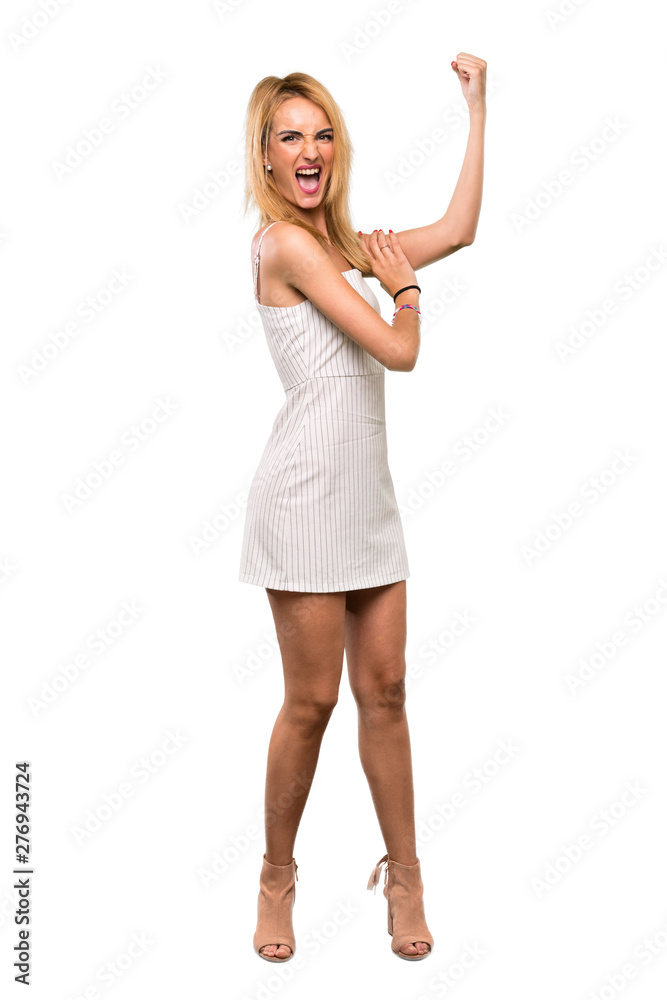 A full-length shot of a Young blonde woman doing strong gesture over isolated white background A full-length shot of a Young blonde woman doing strong gesture over isolated white background