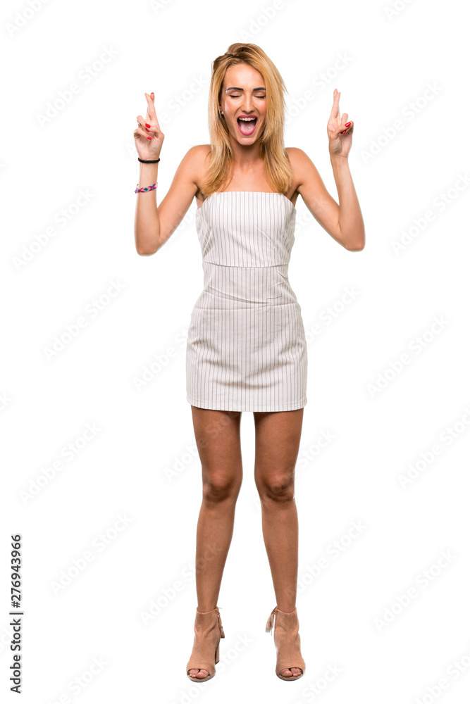 A full-length shot of a Young blonde woman with fingers crossing over isolated white background A full-length shot of a Young blonde woman with fingers crossing over isolated white background