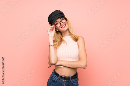 Young blonde woman with hat with glasses and happy