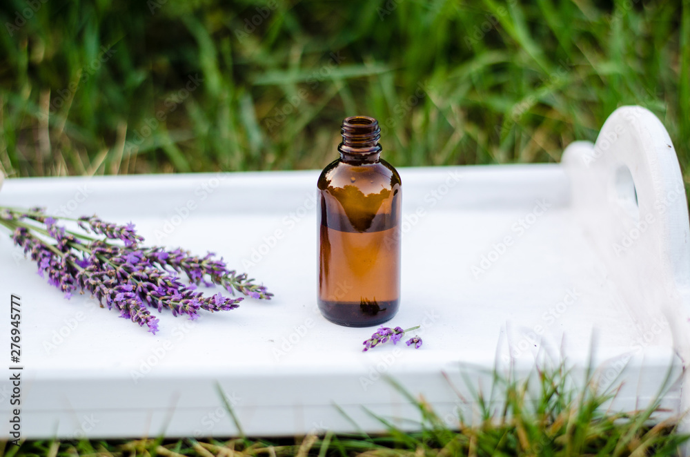 Lavender essential oil. Dark bottle of essential oil with fresh lavender twigs. natural face and body beauty care concept. Lavender essential oil. Dark bottle of essential oil with fresh lavender twigs. natural face and body beauty care concept.