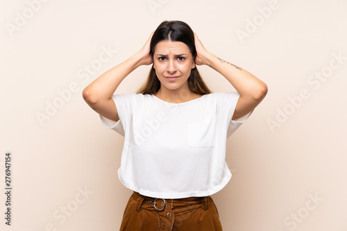 Young brunette woman over isolated background frustrated and takes hands on head © luismolinero