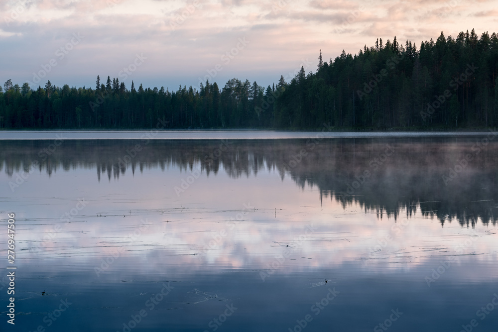 Misty Sunrise over a finnish lake in dark forest with beautiful reflections, Kainuu, Finland