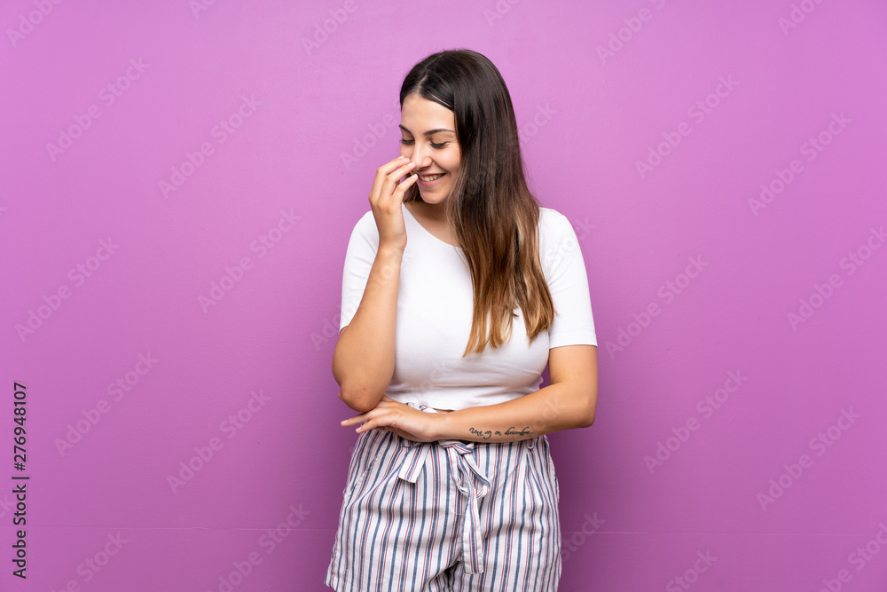 Young woman over isolated purple background smiling a lot Young woman over isolated purple background smiling a lot