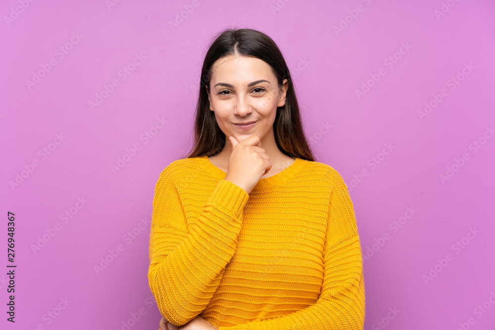 Young woman over isolated purple background laughing