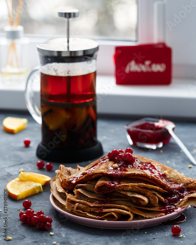 Pancakes with raspberry jam and teapot with fruit tea