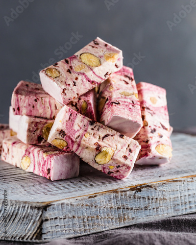 Front view of pink nougat candies with berries and nuts