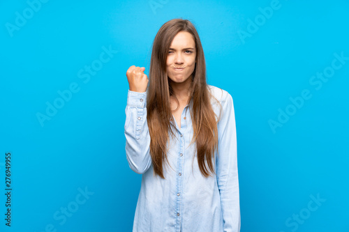 Young woman over isolated blue background with angry gesture
