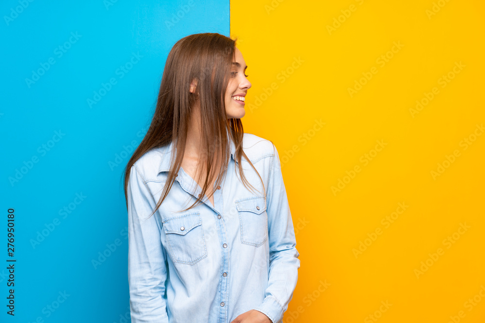 Young woman over colorful background looking to the side Young woman over colorful background looking to the side