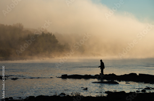 Fisherman on a river at the sunrise