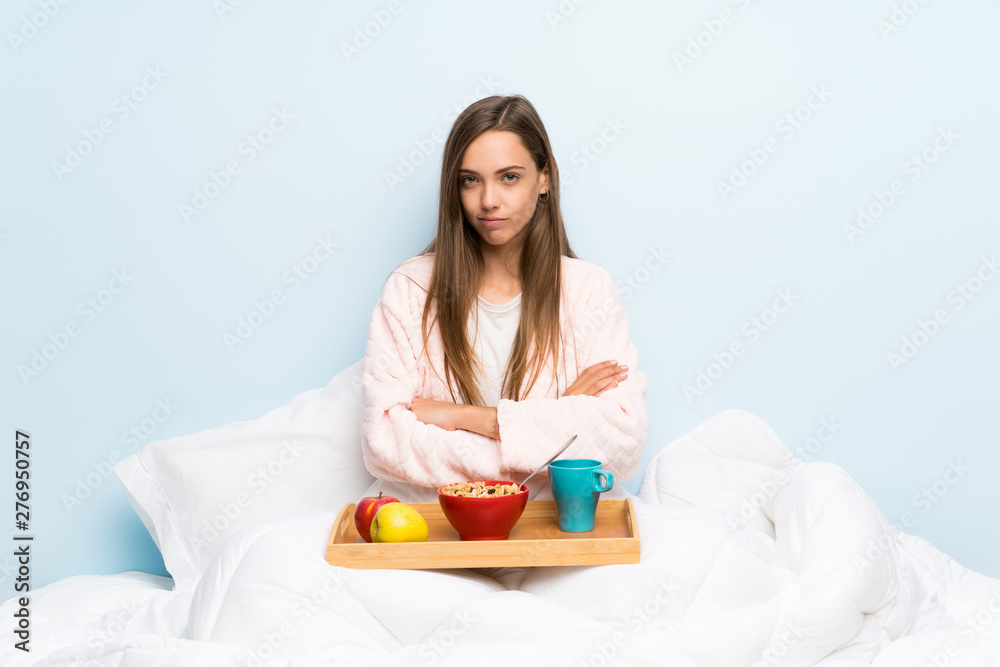 Young woman in dressing gown with breakfast keeping arms crossed Young woman in dressing gown with breakfast keeping arms crossed