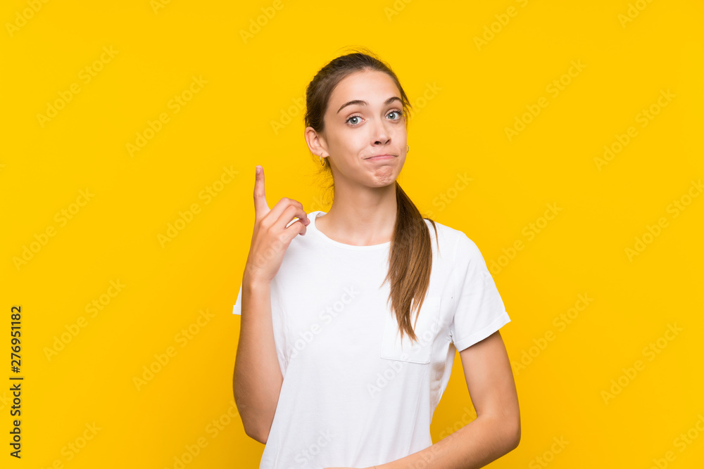 Young woman over isolated yellow background pointing with the index finger a great idea Young woman over isolated yellow background pointing with the index finger a great idea