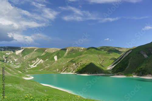 Top view of the mountain lake Kezenoi am — the largest lake in the area of the Chechen Republic and the Greater Caucasus . Bright green on the slopes. Sunny day