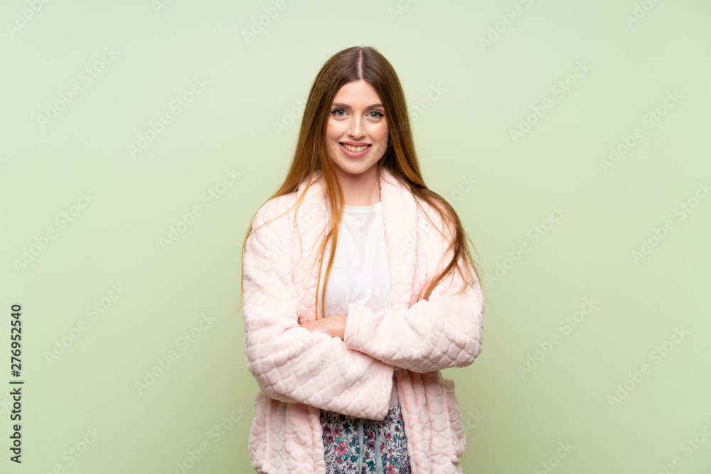 Young woman in dressing gown over green wall laughing Young woman in dressing gown over green wall laughing