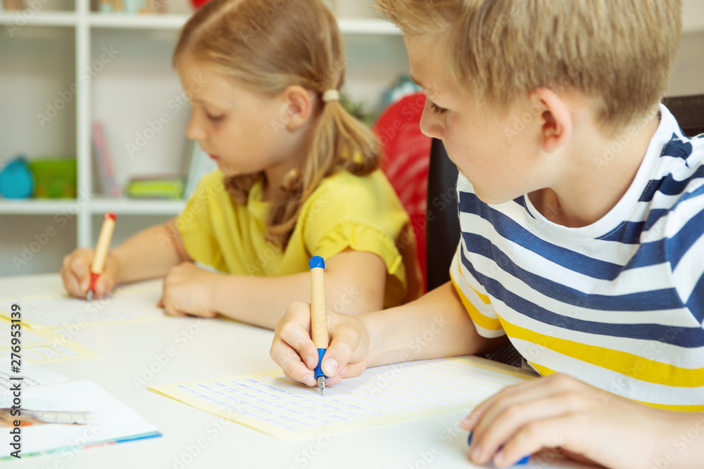 Cute schoolchildren are came back to school and learning at the table in classroom Cute schoolchildren are came back to school and learning at the table in classroom