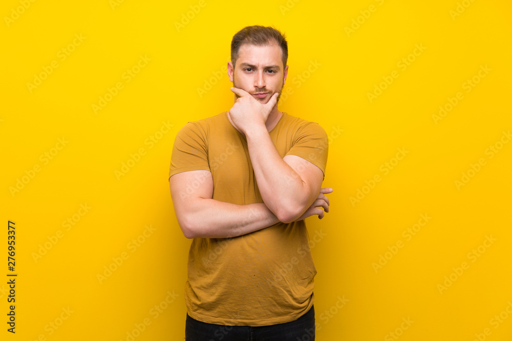 Blonde man over isolated yellow wall thinking Blonde man over isolated yellow wall thinking