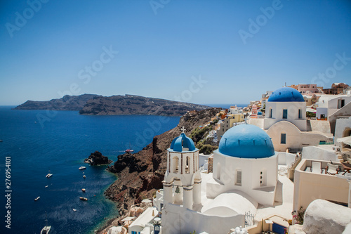 Oia town on Santorini island, Greece. View of traditional white houses and churches with blue domes over the Caldera © Sahaidachnyi Roman