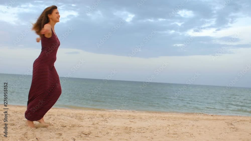 cheerful girl running, spinning round and dancing on the beach barefoot in a dress, happy young woman on the seaside enjoys life, concept summer vacation, lifestyle cheerful girl running, spinning round and dancing on the beach barefoot in a dress, happy young woman on the seaside enjoys life, concept summer vacation, lifestyle