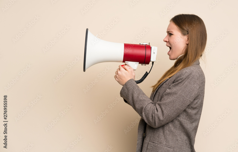 Young business woman shouting through a megaphone Young business woman shouting through a megaphone