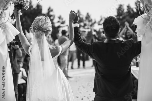 A bride and a groom are celebrating. Black and white image.