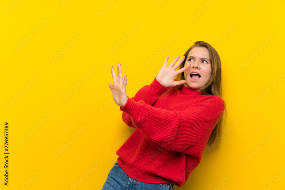 Young woman over yellow wall nervous and scared Young woman over yellow wall nervous and scared