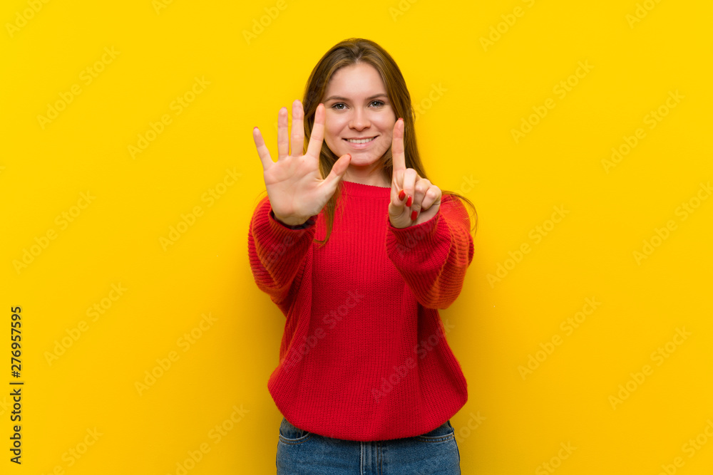 Young woman over yellow wall counting six with fingers Young woman over yellow wall counting six with fingers