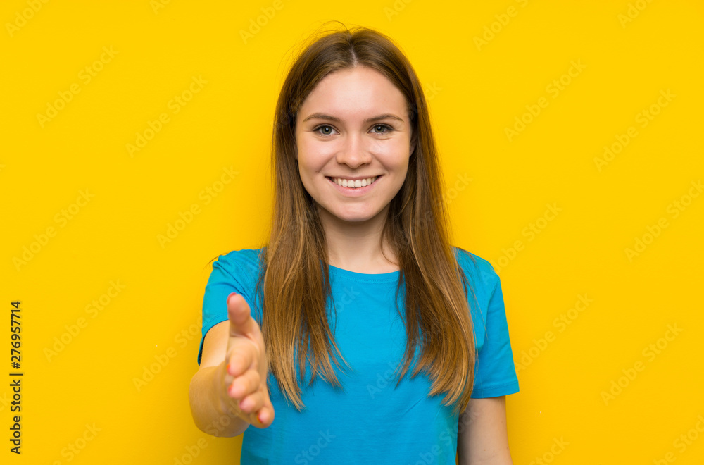 Young woman with blue shirt handshaking after good deal Young woman with blue shirt handshaking after good deal
