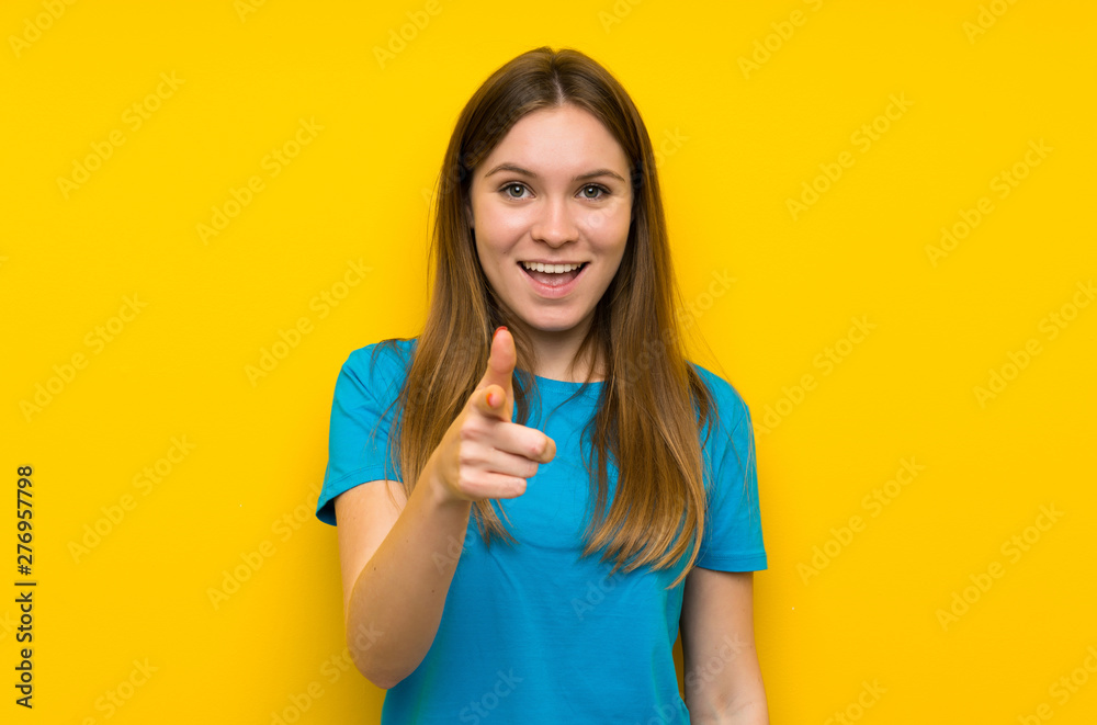 Young woman with blue shirt points finger at you Young woman with blue shirt points finger at you