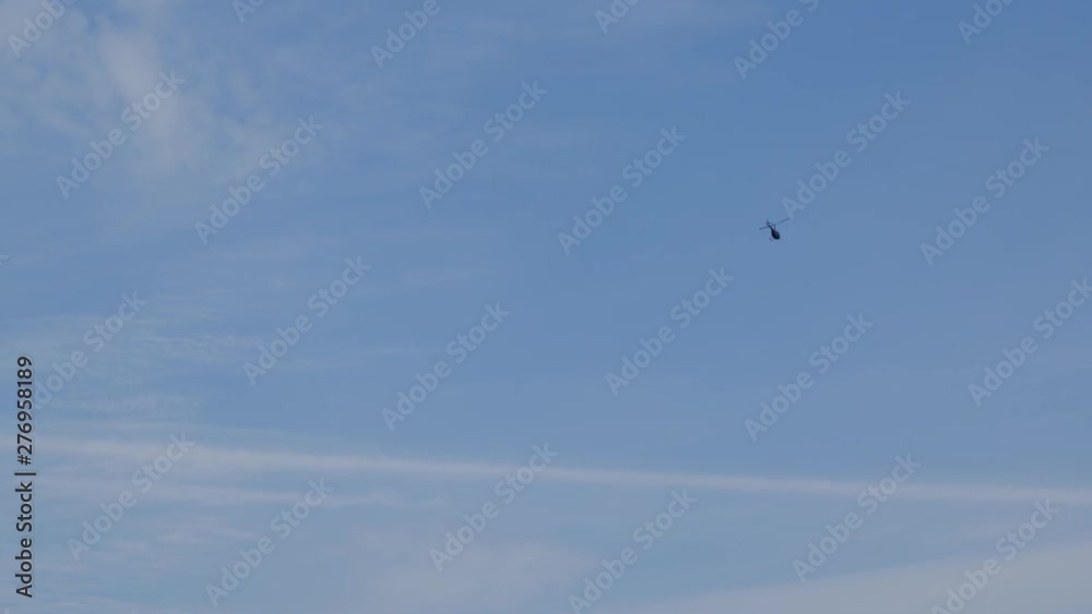 Helicopter flying away from the camera with a blue sky and some clouds. Helicopter flying away from the camera with a blue sky and some clouds.