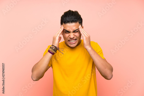 Young man with yellow shirt over isolated pink wall unhappy and frustrated with something. Negative facial expression © luismolinero