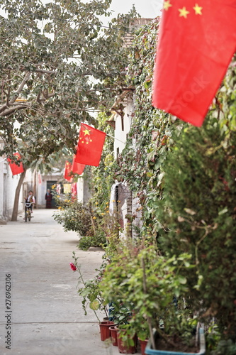 Backstreet with chinese flags-rear area of the Sunday Market. Hotan-Xinjiang-China-0121