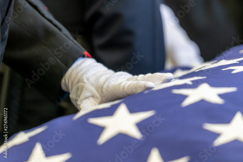 Hand with gloves touches an American Flag