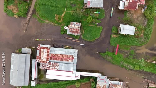 Medium high-angle circular motion pan shot of water-channel routes and boats sailing  between floating village houses in Inle Lake, Shan State, Myanmar photo