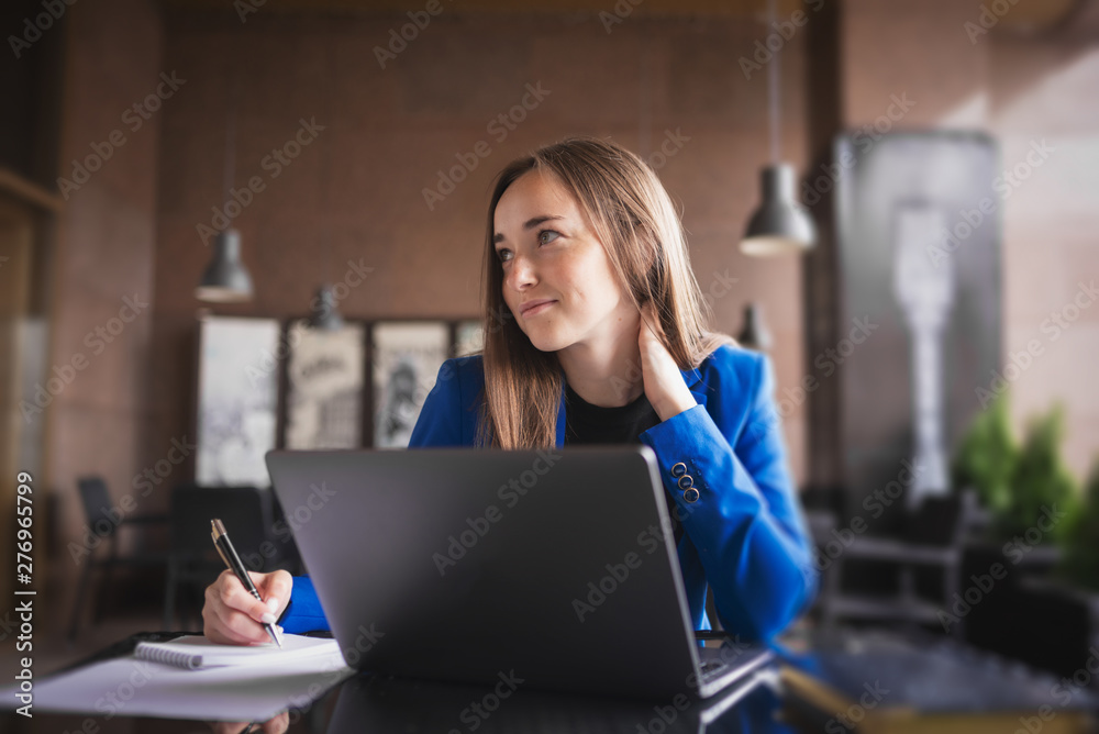Beautiful business woman with a laptop and notebook looks thoughtfully Beautiful business woman with a laptop and notebook looks thoughtfully