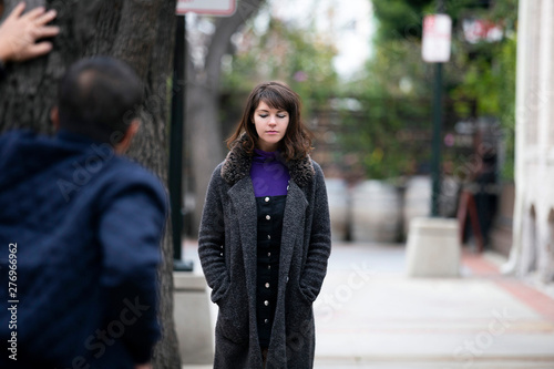 Man being rude, leering and cat calling or sexually harassing a woman walking on the street.  Also depicts crime and safety with a stalker following a female victim.
