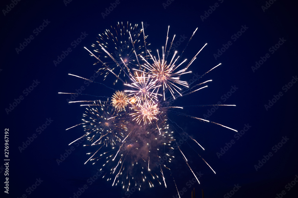 Cheap bright sparkling fireworks, white-yellow, with haze, in the night sky Cheap bright sparkling fireworks, white-yellow, with haze, in the night sky