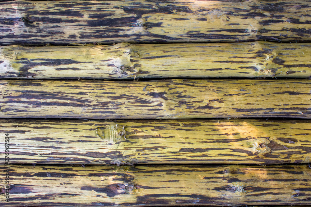 old brown yellow wall fence of large tree trunks. horizontal lines. natural surface texture old brown yellow wall fence of large tree trunks. horizontal lines. natural surface texture
