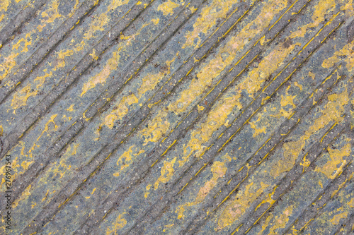old gray concrete wall with yellow peeling paint and diagonal lines. rough surface texture