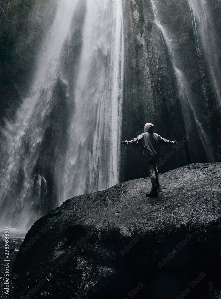 Obraz premium A person admirnig the beauty of Skogafoss waterfall located in Iceland