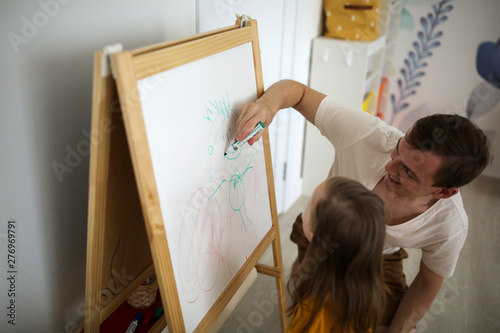 Girl with Down syndrome and dad paint with marker