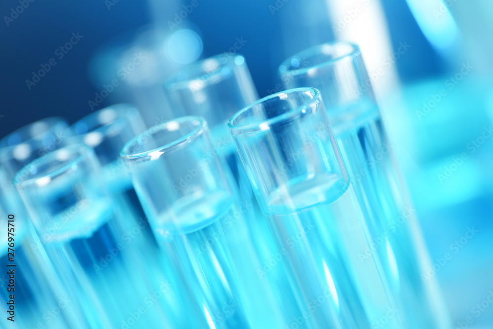 Test tubes with liquid on blue background, closeup. Solution chemistry Test tubes with liquid on blue background, closeup. Solution chemistry