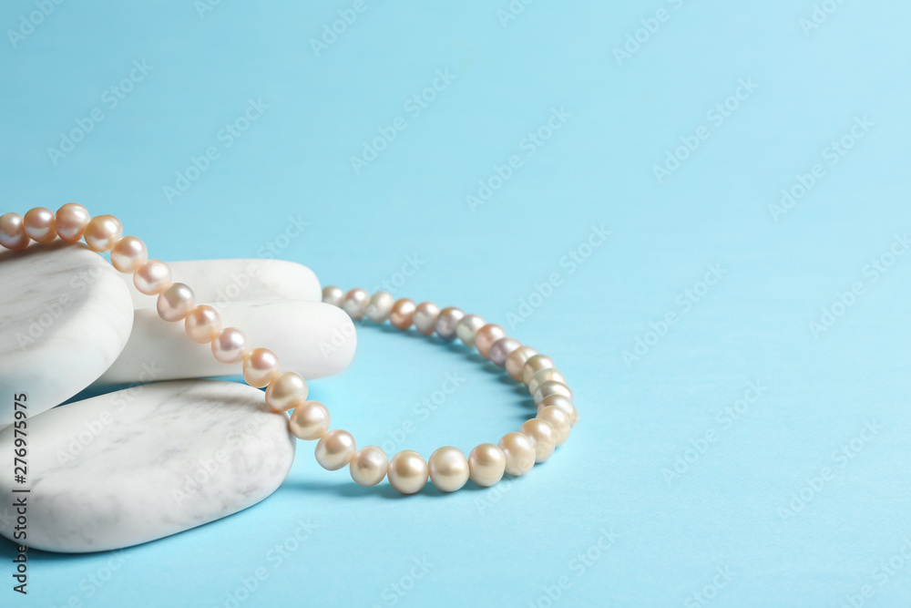 White marble stones with elegant jewelry on light blue background. Space for text