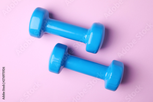 Bright dumbbells on color background, flat lay. Home fitness